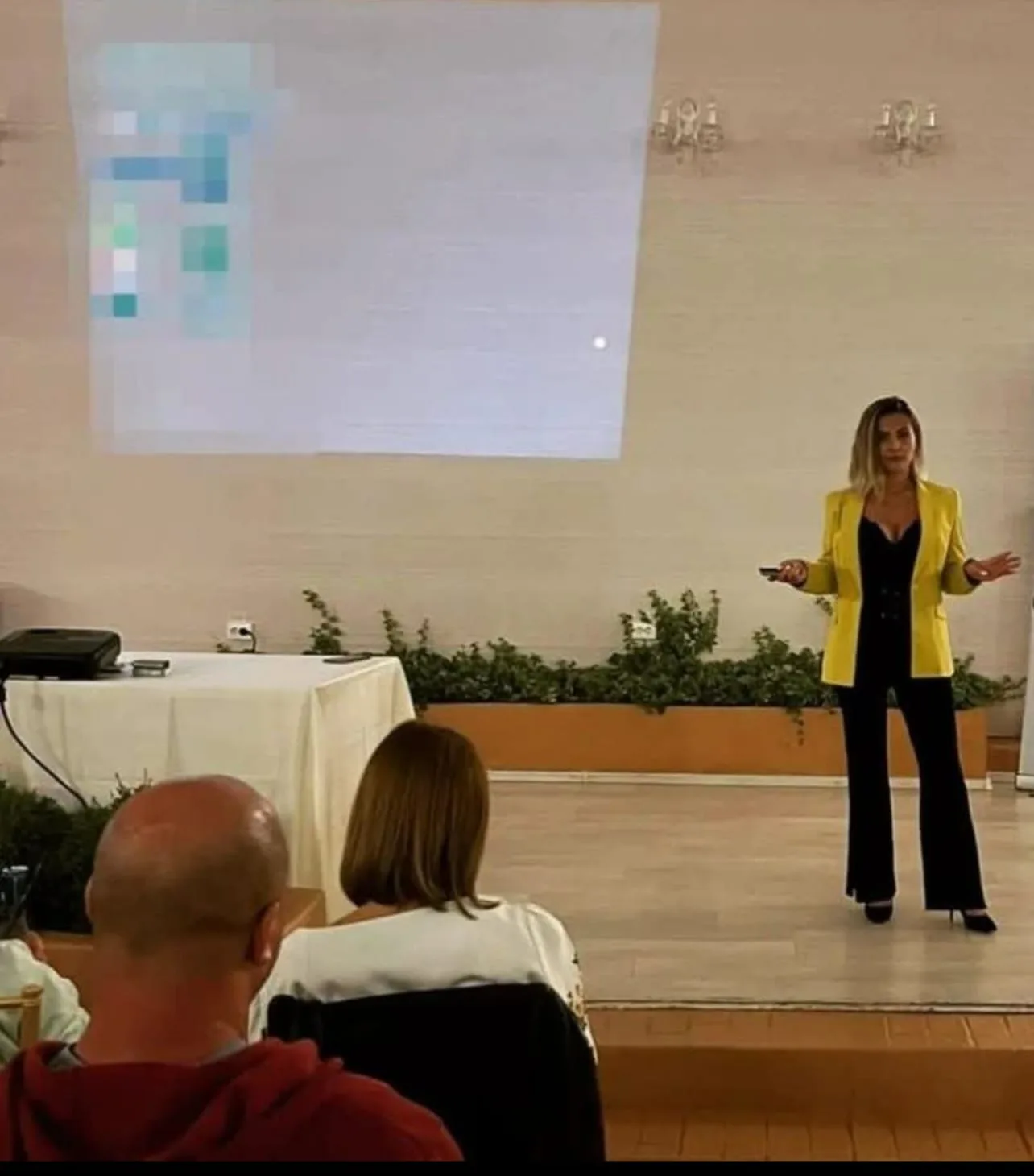 Alexa Nica, în sacou galben, susține un training de pe scenă în fața participanților